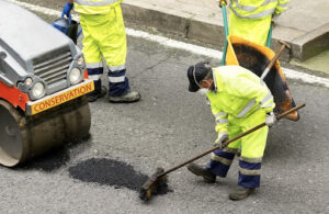 men fixing pothole | pothole patching