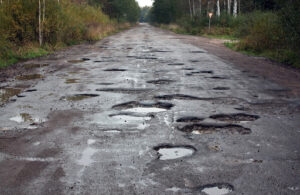 road full of potholes | potholes on asphalt